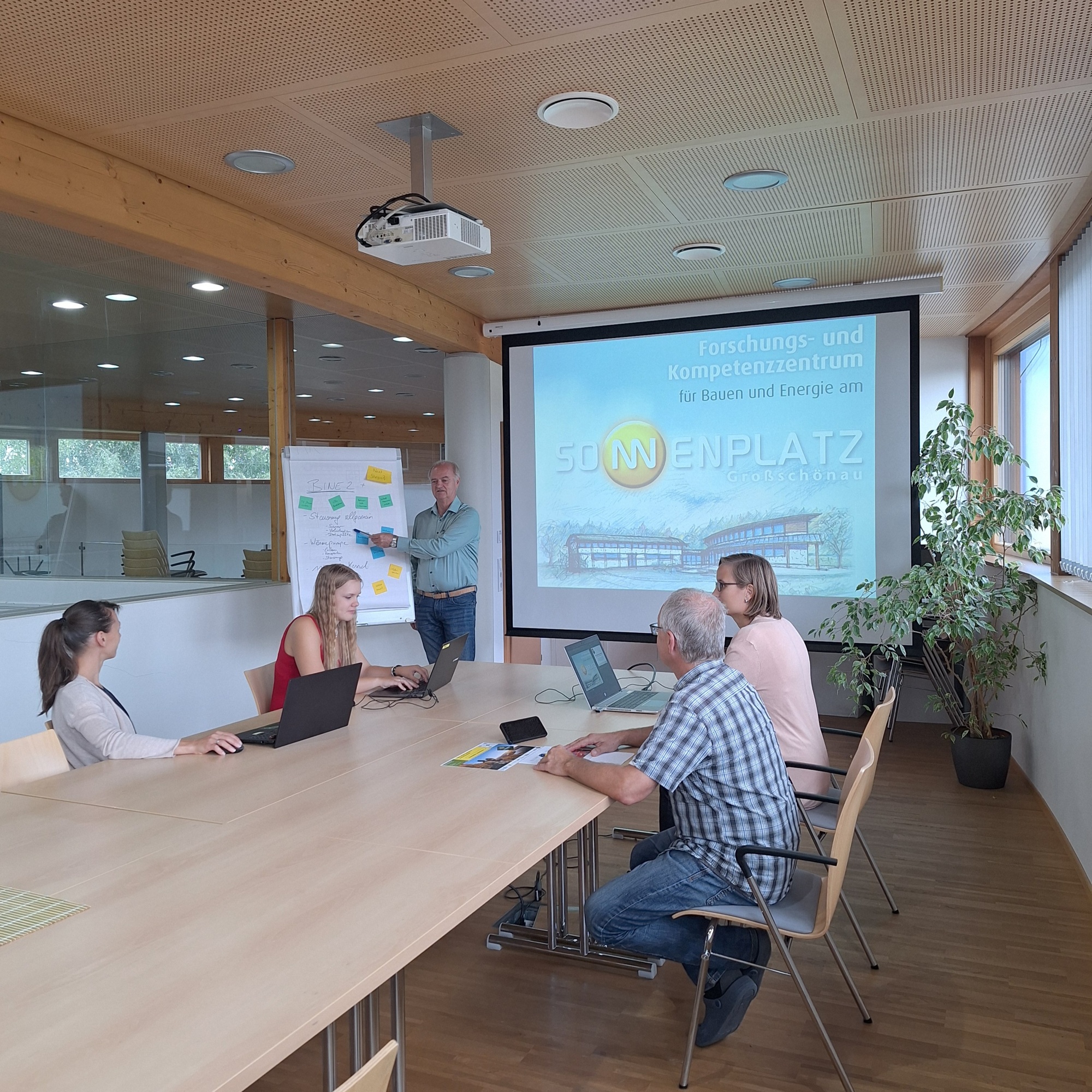 Vier Personen bei einer Projektbesprechung am Tisch.